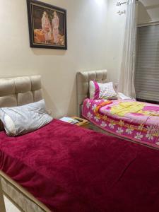 西迪拉哈尔Casabay kettani的一间卧室设有两张床和窗户。