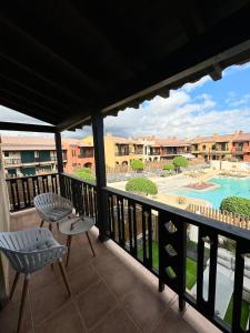 圣米格尔德阿沃纳San Blas Golf del Sur Residence的阳台配有两把椅子,享有游泳池的景色