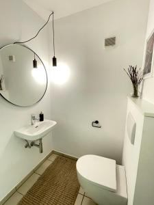 洛豪SUNSET Apartment direkt am Bodensee mit Parkplatz的白色的浴室设有卫生间和水槽。