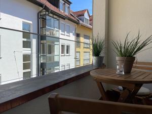 布雷根茨VINCENT Apartment in Bregenz mit Parkplatz的阳台配有桌子和盆栽植物