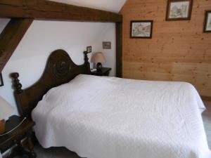 布勒斯海姆A l'arc en ciel的卧室设有白色的床和木墙