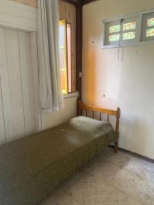 特雷索波利斯Aldeia Gaia Chalés的一间带床的卧室,位于带窗户的房间内
