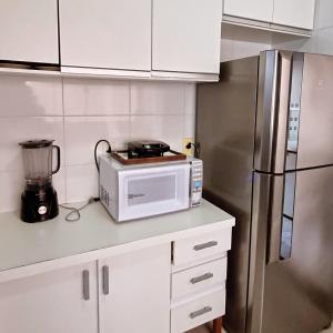 锡诺普Sobrado privativo com suite的厨房配有微波炉和冰箱。