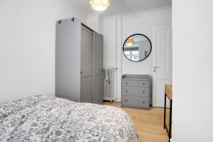哥本哈根Perfectly located cozy apartment的白色卧室配有床和镜子