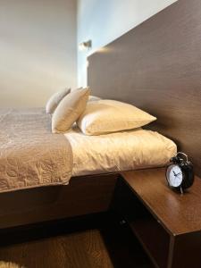 科希策AR GOLDEN HOUSE的一张带枕头的床和一张桌子上的闹钟
