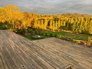 NgaruawahiaPerma Ridge Farmstay的大型木制甲板享有花园景色