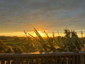 NgaruawahiaPerma Ridge Farmstay的甲板上可欣赏到日落美景