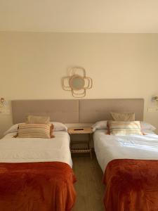 纳维亚Pensión Cantabrico的两张睡床彼此相邻,位于一个房间里