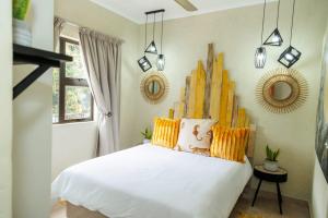 内尔斯普雷特Pumbaa Wildlife Park & Accommodation的一间卧室配有白色床和黄色枕头