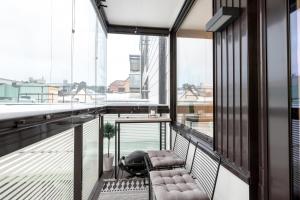 赫尔辛基2ndhomes Gorgeous and Modern 2BR Apartment with Balcony的阳台设有长凳和一些窗户。