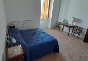 CamardaLocanda di Posta的一间卧室配有一张蓝色的床和一张桌子