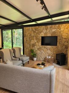 圣罗克CHALÉ NAMATA 201的带沙发和石墙的客厅