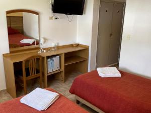 米娜克拉韦罗Hotel Rossetti y Spa的客房设有两张床和一张带镜子的书桌