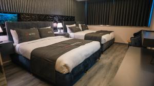 伊斯坦布尔CIP Hotel的酒店客房设有两张床和电视。