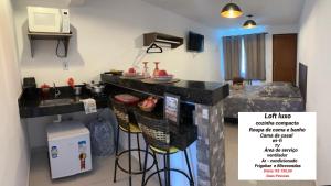 里约达欧特拉斯Loft Casa Feliz的厨房配有带凳子和水槽的台面