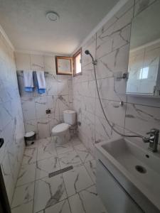 Къща за гости Люляк的白色的浴室设有卫生间和水槽。