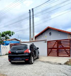 伊塔尼亚恩Doce Refugio Itanhaém的车库前的黑色汽车