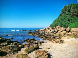 伊塔尼亚恩Doce Refugio Itanhaém的海边沙滩上的一群岩石