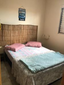 伊塔尼亚恩Doce Refugio Itanhaém的一间卧室配有一张带粉红色和蓝色床单的床