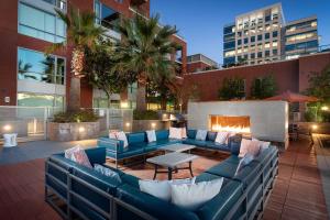 圣何塞Global Luxury Suites San Jose Downtown的一个带蓝色沙发和壁炉的庭院