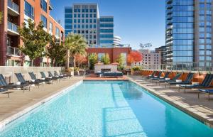 圣何塞Global Luxury Suites San Jose Downtown的大楼内一个带躺椅的游泳池
