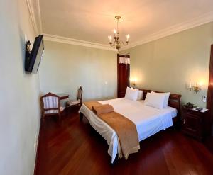佩德拉阿祖尔阿罗索帕考酒店的卧室配有一张白色大床和吊灯。
