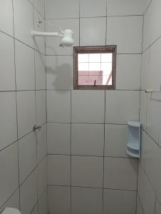 PalmasTedesco的白色瓷砖浴室设有窗户和卫生间