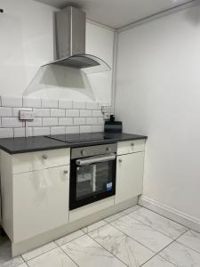 伦敦Double bedroom with bathroom en suite in London Docklands Canary Wharf E14的厨房配有白色橱柜和炉灶烤箱。