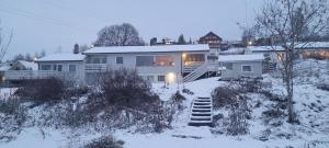 利勒斯特罗姆Hus ved Lillestrøm by的雪中的房子,有雪覆盖的院子