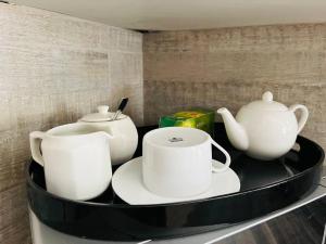 勒斯滕堡Private room in Rustenburg的上面有白杯和茶壶的架子