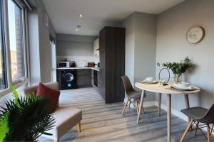 谢菲尔德Inviting 1-Bed Apartment in the heart of Sheffield的一间带桌椅的客厅和一间厨房