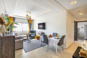 马拉喀什Cozy 2-bedroom apartment in Gueliz, Marrakech的用餐室以及带桌椅的起居室。