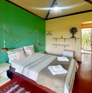 戈亚斯州上帕莱索Pousada Paralelo 14的一间卧室设有一张大床和绿色的墙壁