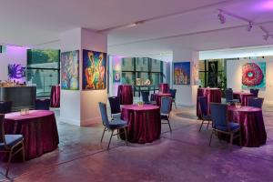 新奥尔良万豪奢华生活方式酒店 - 文艺复兴新奥尔良艺术仓库区酒店的配有桌椅和壁画的房间