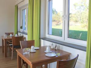 GaimersheimGästehaus am Reisberg的一间带木桌和窗户的用餐室