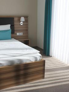 GaimersheimGästehaus am Reisberg的一间卧室配有一张带木制床头板和窗帘的床。