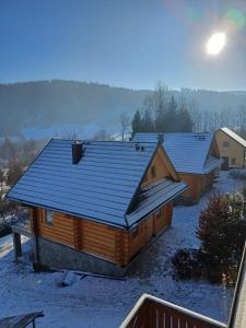 Domki po balu的雪中带蓝色屋顶的小木屋