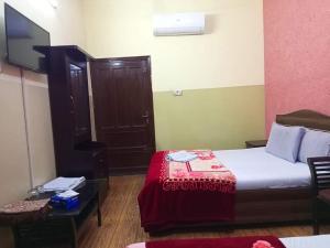 卡拉奇Furnish Rooms Near Jinnah Airport的酒店客房,配有床和电视