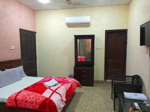 卡拉奇Furnish Rooms Near Jinnah Airport的一间卧室配有一张床铺,床上铺有红色毯子