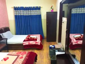 卡拉奇Furnish Rooms Near Jinnah Airport的带两张床和镜子的客房