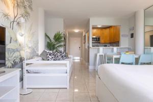 迈阿密海滩Vista Mar: Bay Views Close to Miami Attractions的一间带白色床的卧室和一间厨房