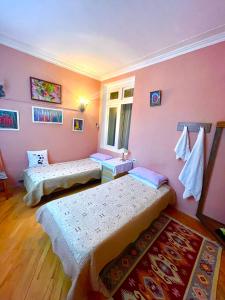 巴库My Home Guest House的配有粉红色墙壁的客房内的两张床