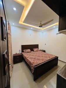 GujrānwālaCapital Lodges的一间卧室设有一张床和天花板