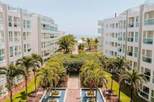 帕纳米林Qavi - Flat Resort Beira Mar Cotovelo #InMare133的享有棕榈树庭院和建筑的空中景致