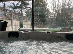 维勒班特Appt privé, Jaccuzi pro, 2 pers, 100m2, jardin, proche, Parc des Expositions, Aéroport CDG, Villepinte的窗户旁的浴缸里装满了雪