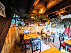 RougnatLe Noyer的一间带木桌椅的餐厅和一间酒吧
