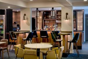 普利茅斯会议费城普利茅斯米庭万怡酒店的一间带桌椅的餐厅和一间酒吧