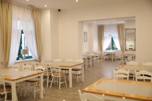斯维诺乌伊希切Koral Świnoujście的用餐室设有桌椅和窗户。