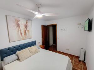扎哈拉Casa Rural Agua de Azahar Chimenea的卧室配有白色的床和吊扇