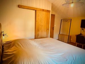 奥埃Prim'tout的卧室配有白色的床和木门